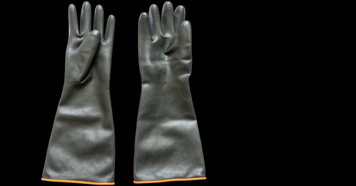 A pair of long industrial rubber gloves with orange trim on the wrists, displayed against a black background.